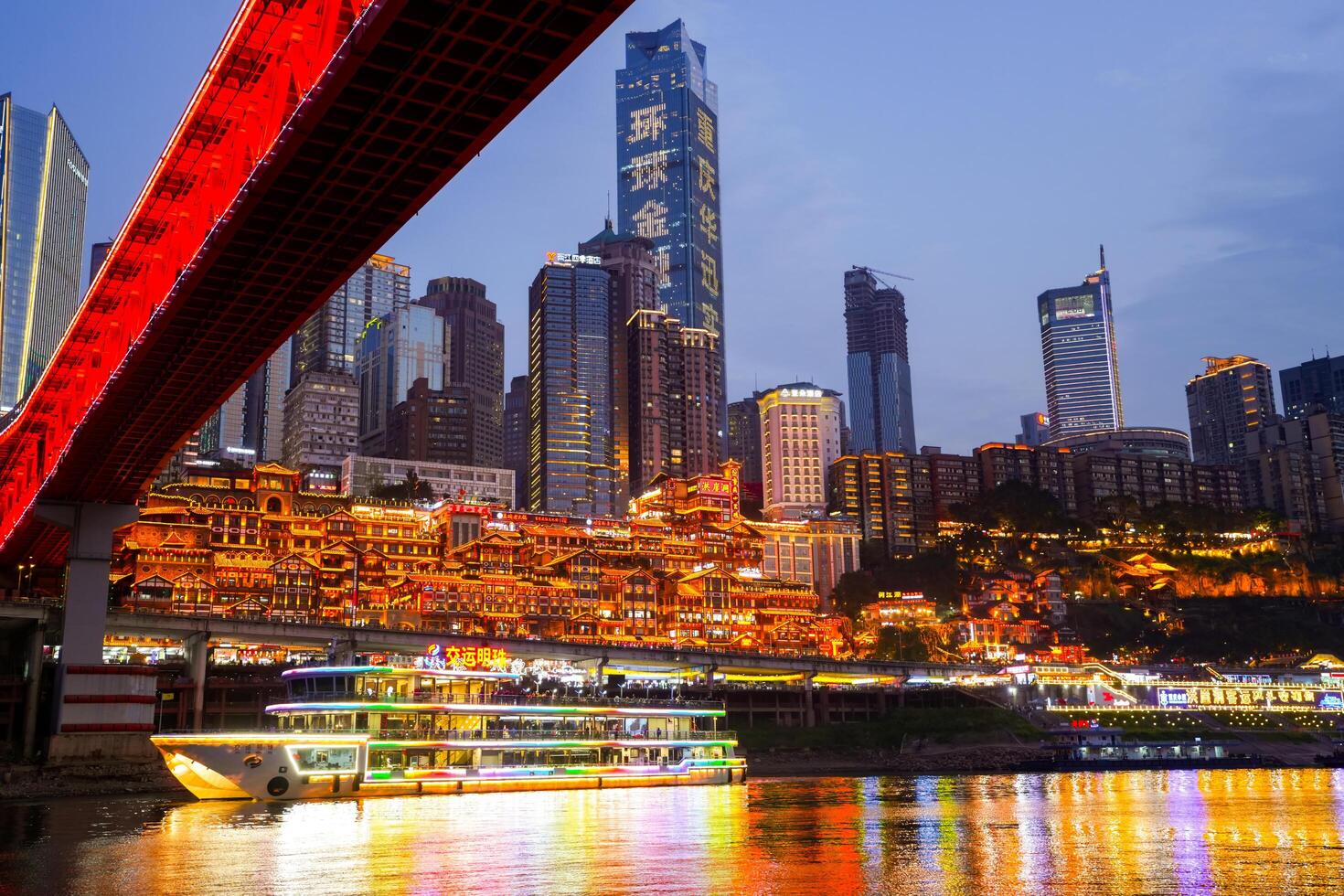 Chongqing, China - APR 02, 2025- Twilight Cityscape of the famous downtown shopping complex Hongyadong with illuminated bridge and highrise building in Chongqing, photo