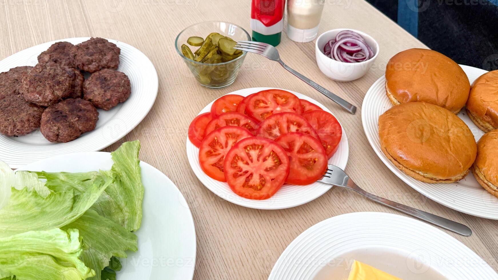 Burger topping ingredients laid out for a backyard barbecue, perfect for summer grilling and Fourth of July celebrations photo