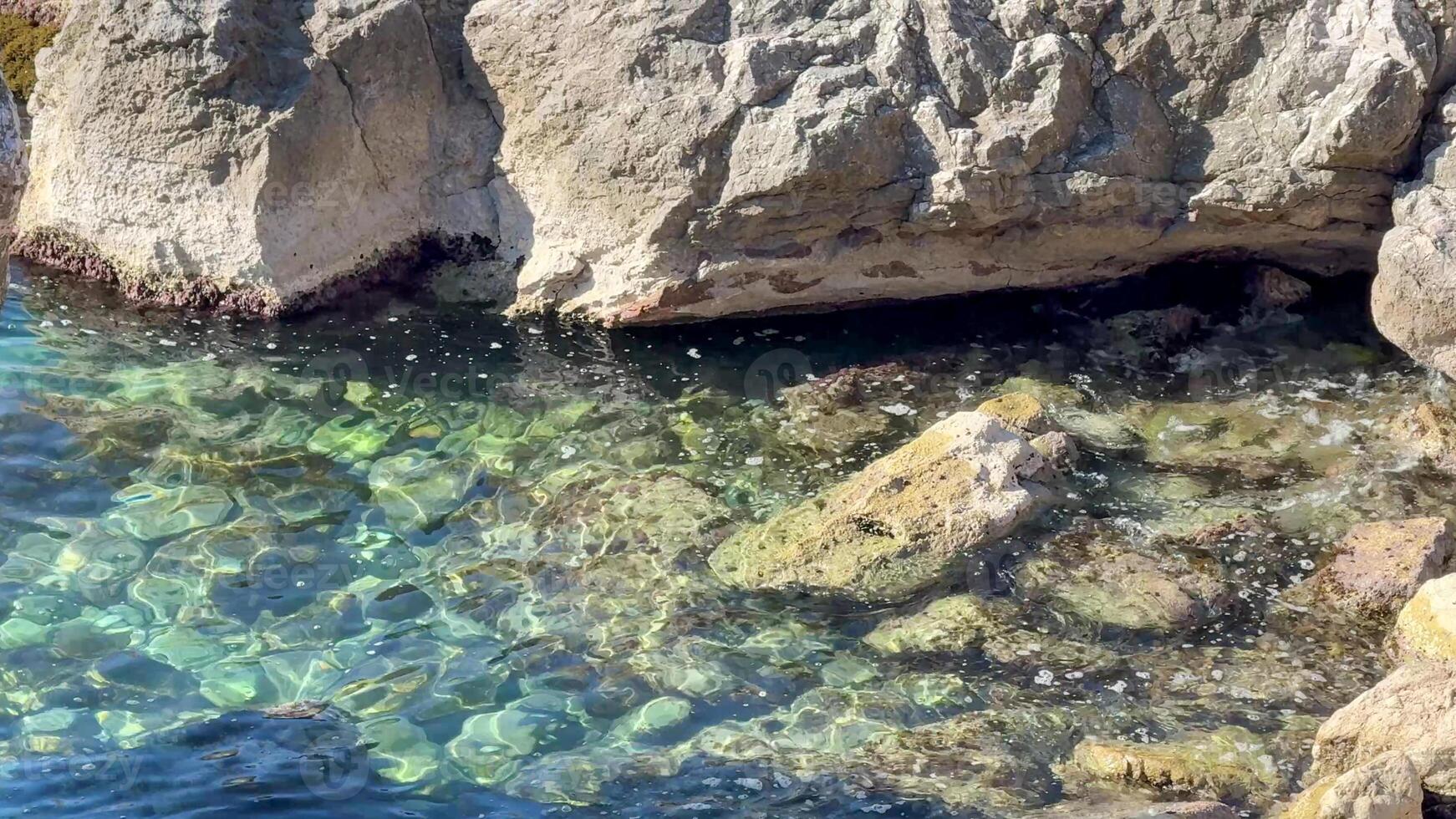 Crystal clear waters and rocky shoreline, perfect for summer vacations and nature exploration, capture serene coastal beauty photo