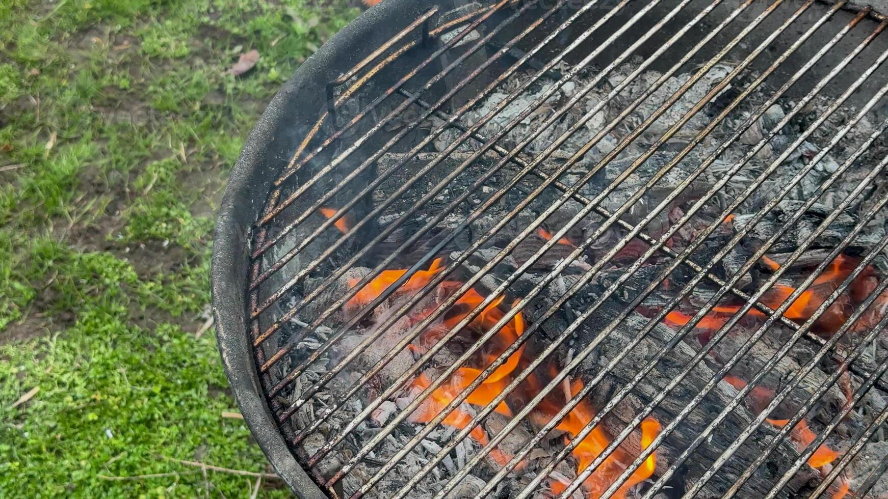 Flames rise from a charcoal grill, perfect for summer barbecues and Fourth of July celebrations, outdoor cooking photo