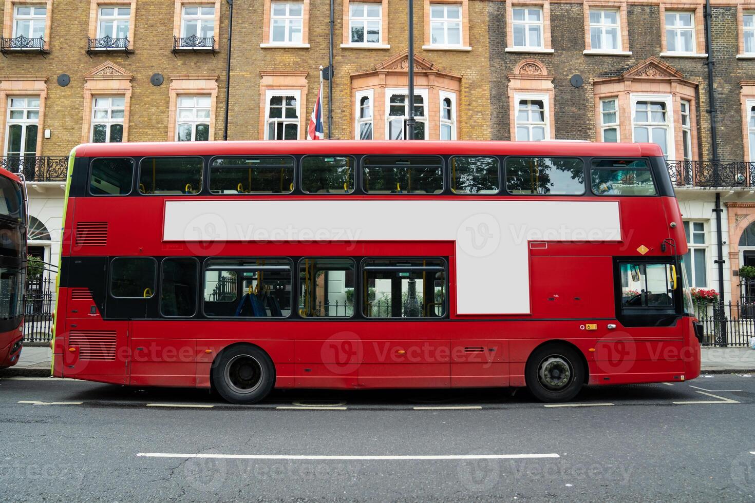 The blank ad space on the red bus contrasts with the classic charm of the calm London street. f photo