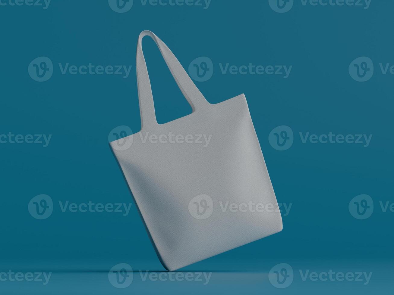 A white tote bag tilted to the left, floating slightly above a vibrant teal background. photo