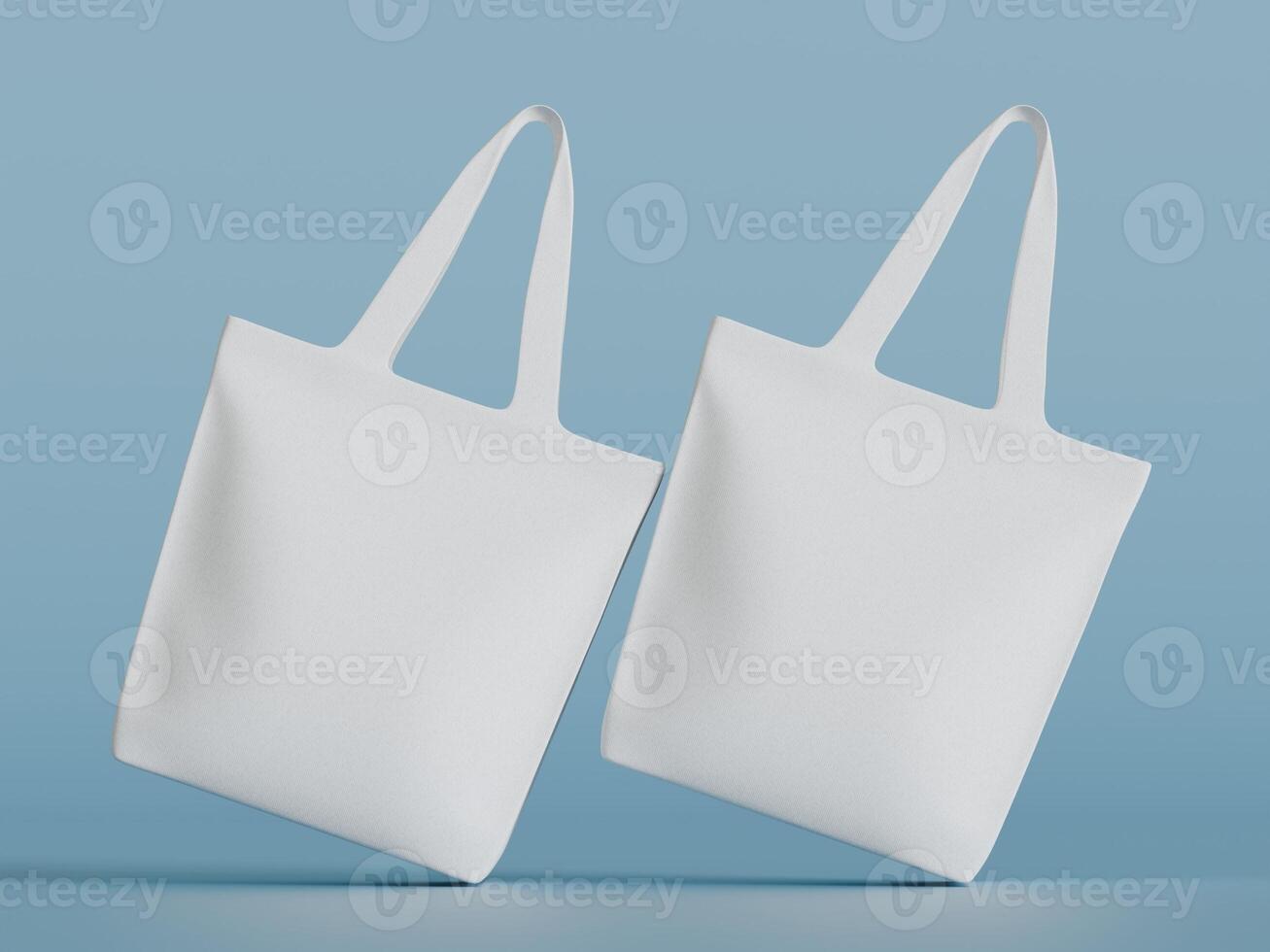 Two white tote bags angled away from each other, floating in front of a light blue background. photo