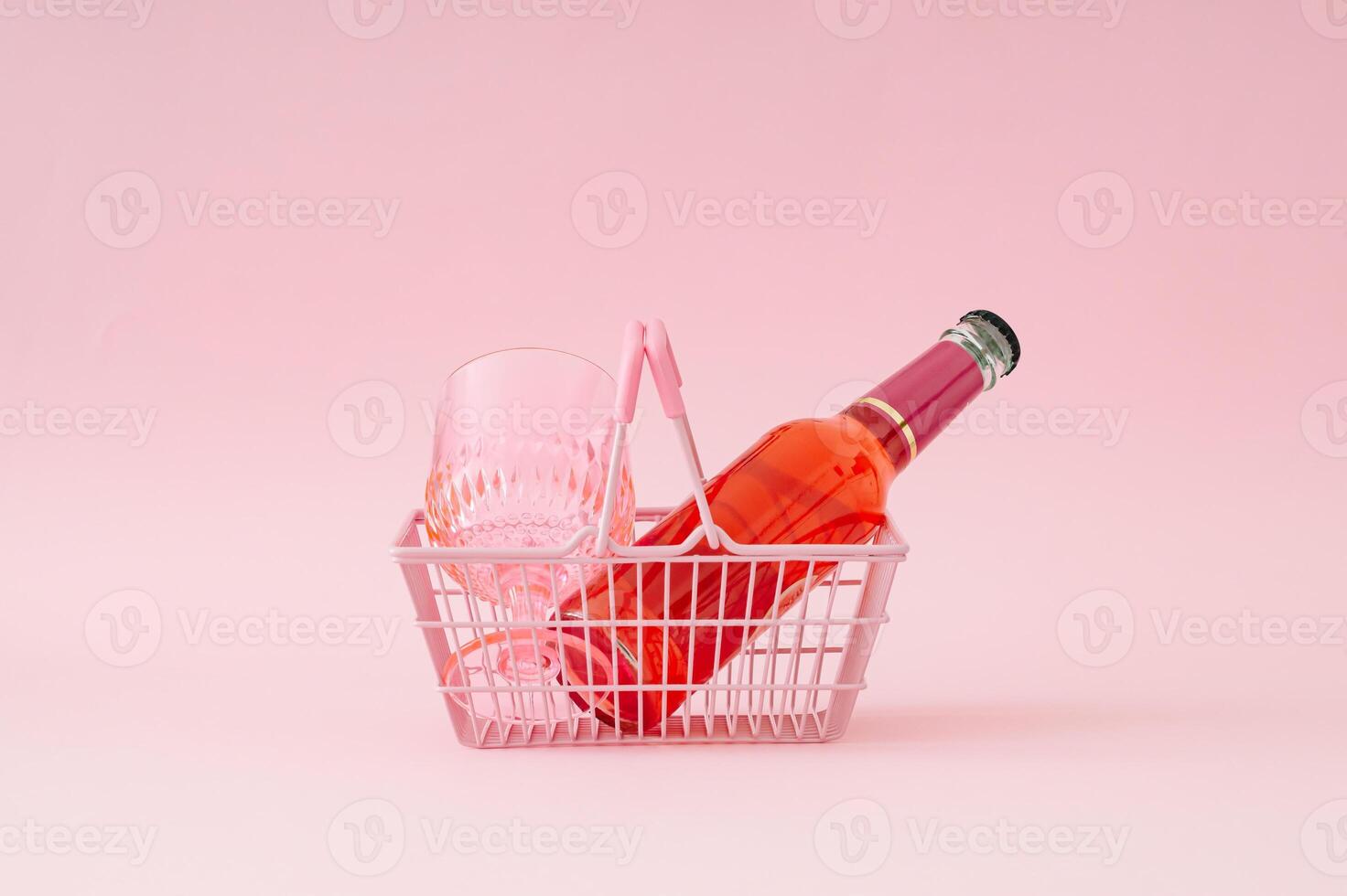 Watermelon drink and pink drinking glass in pink shopping basket on pastel pink background. Minimal refreshing summer drink concept. Trendy summertime party idea. photo