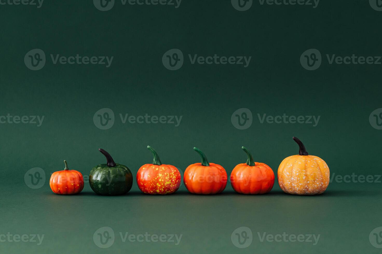 Trendy layout of autumn pumpkins on green background. Creative seasonal concept. Fall aesthetic. photo