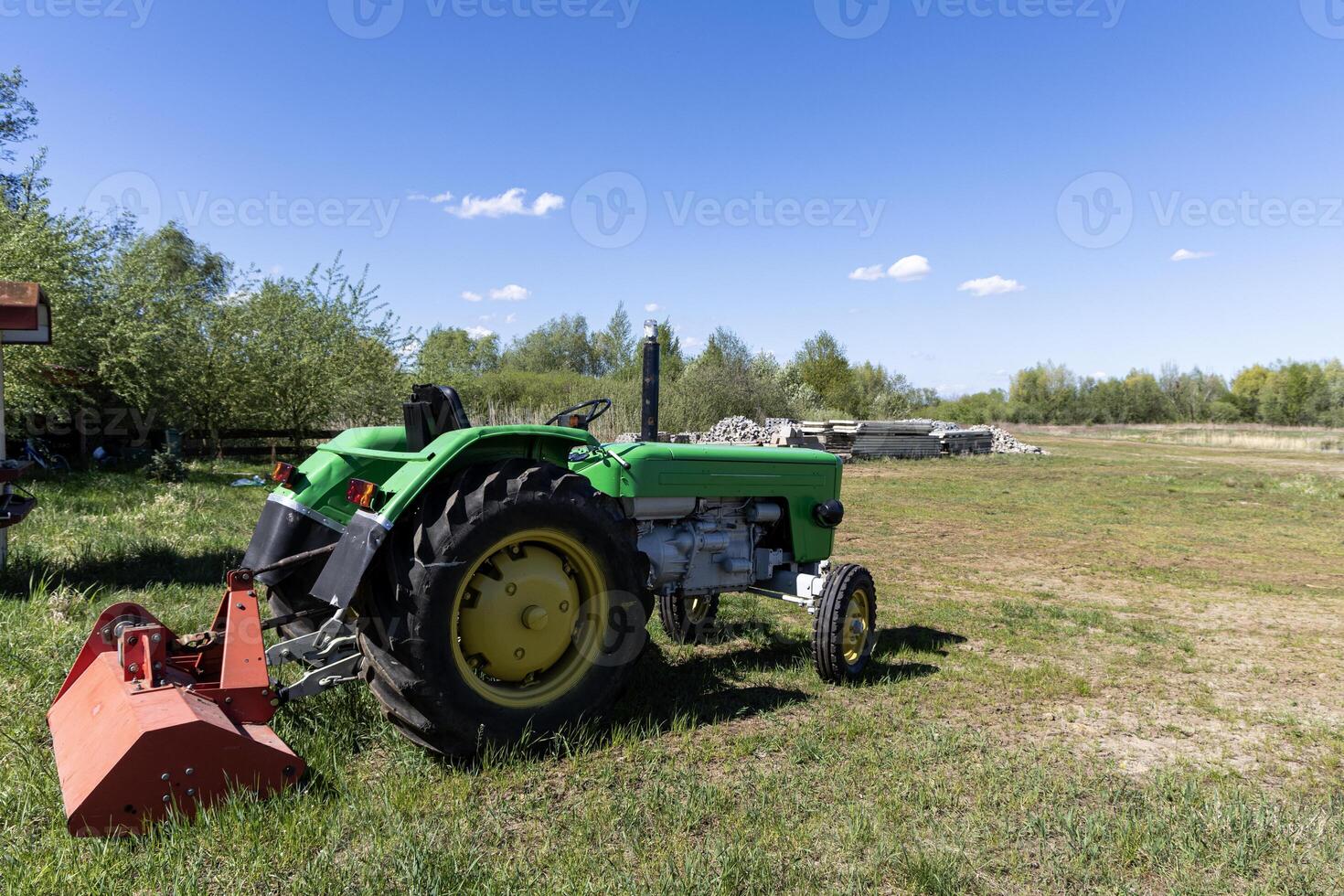 Tractor without a roof, a cabriolet on green grass ready to mow the grass on the site. Poland photo