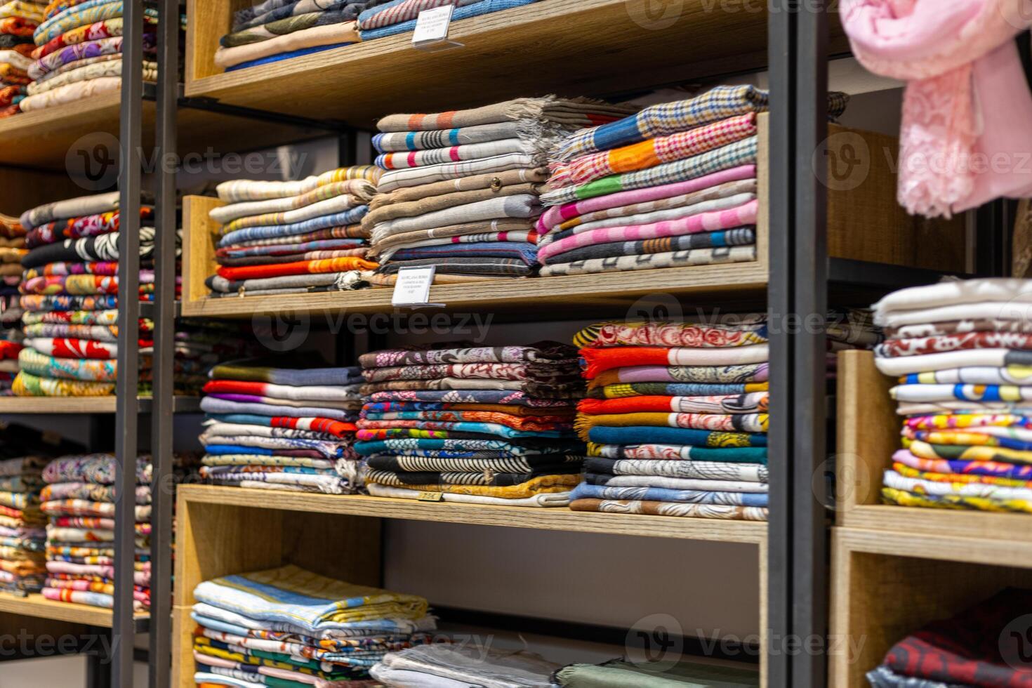 Vibrant display of folded fabrics in a textile shop showcasing various colors and patterns during daytime shopping hours photo