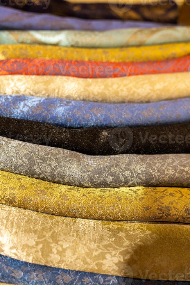 Colorful collection of patterned textiles displayed in a market setting photo