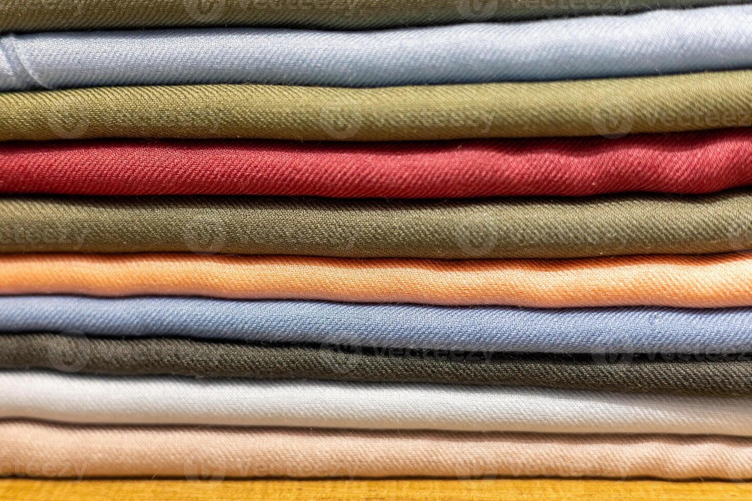 Colorful stack of neatly folded fabric showcasing various textures and hues in a home sewing space photo