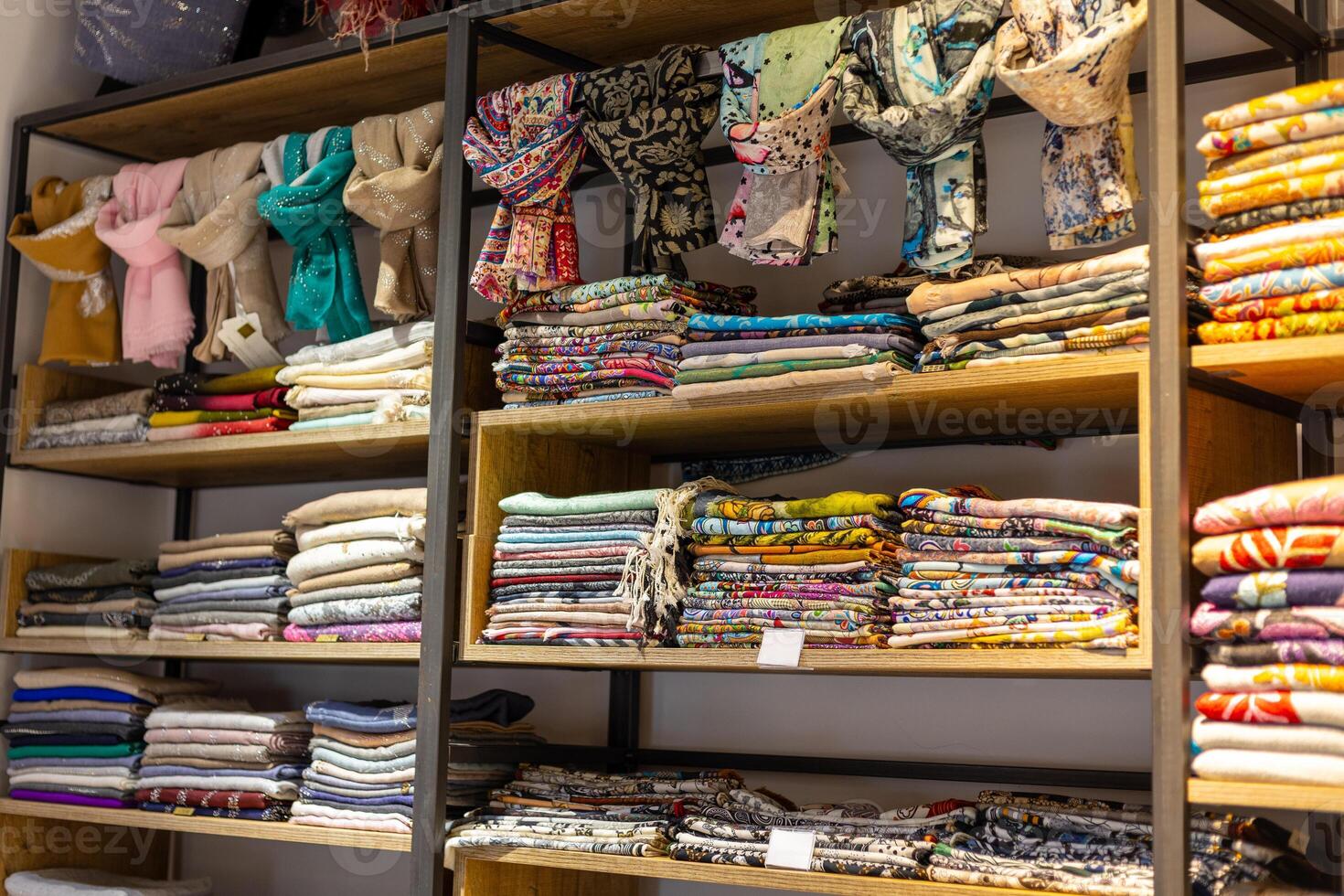 Colorful fabrics and textiles neatly arranged on wooden shelves in a shop inviting creativity and inspiration photo