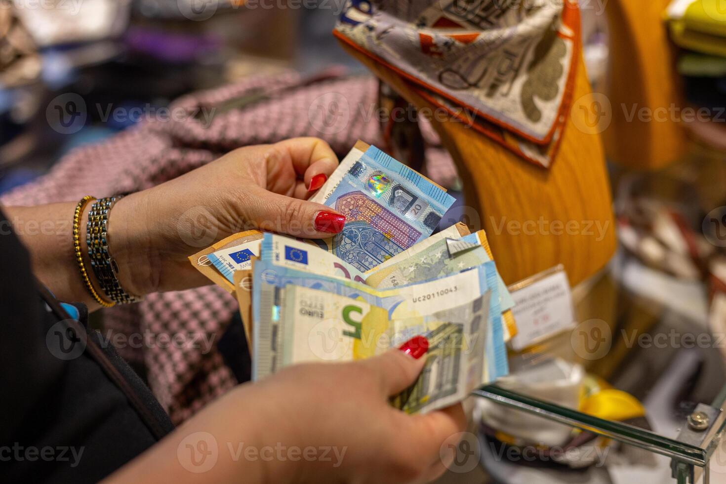 Person counting bills in a store while shopping in an urban location during the daytime photo