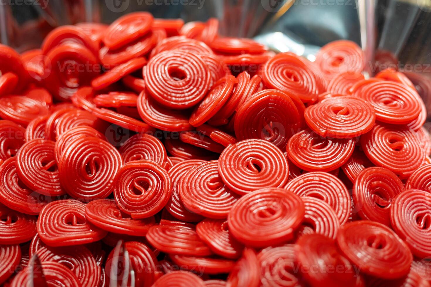 Bright red candy spirals in close-up view, showcasing texture and color at a dessert table during a celebration event photo