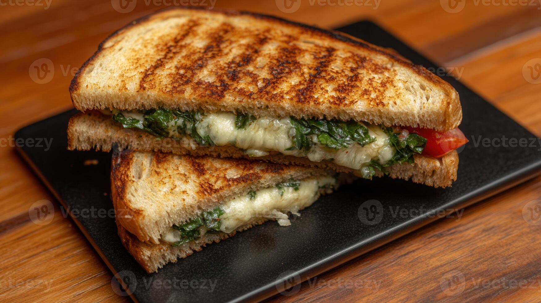 Gourmet grilled sandwich presented on a black plate showcasing its delicious ingredients for an elegant dining experience photo