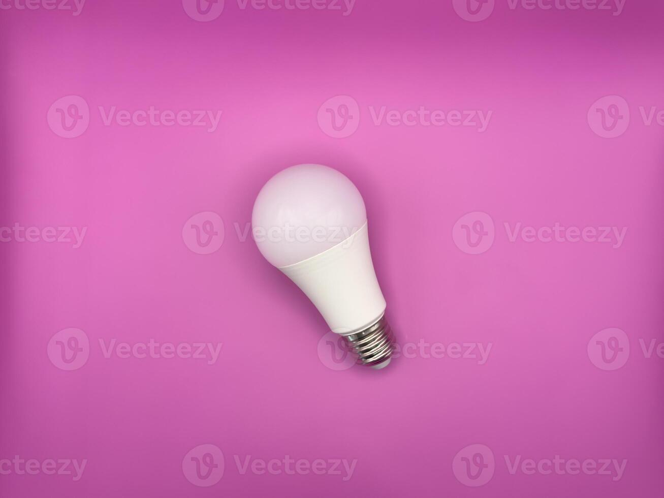 White diode light bulb on purple background without unnecessary objects top view photo