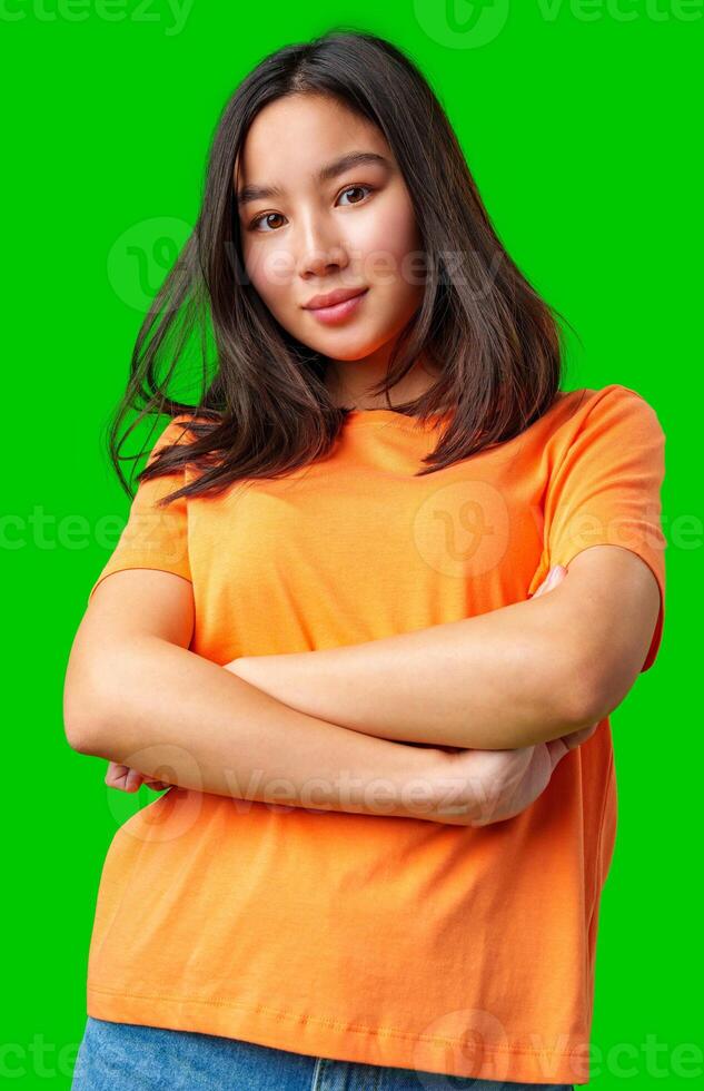 Young woman with a confident pose wearing an orange shirt against a bright green background photo