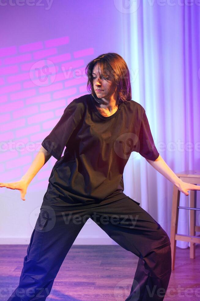 Dynamic contemporary dance performance by a female dancer in a studio with artistic lighting photo