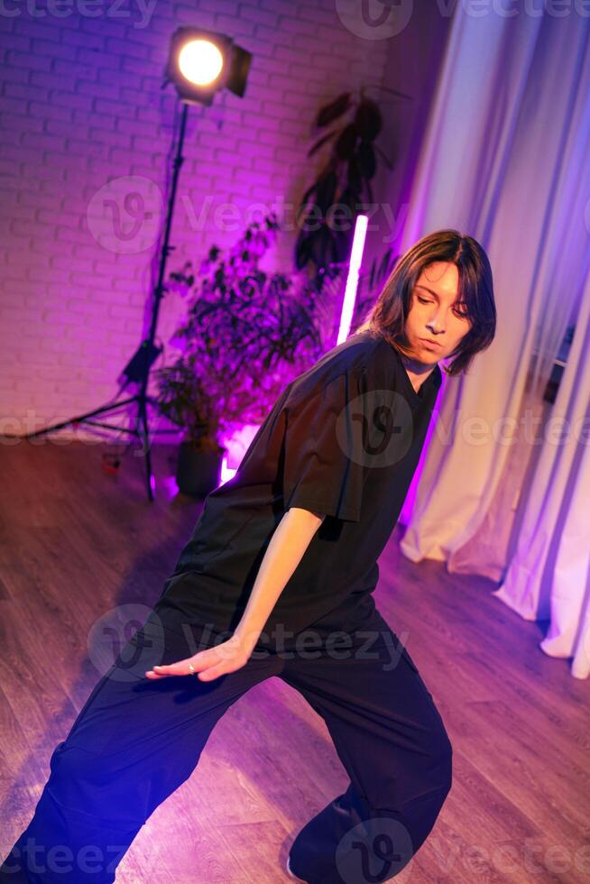Energetic dance performance in a modern studio with vibrant lighting during evening hours photo