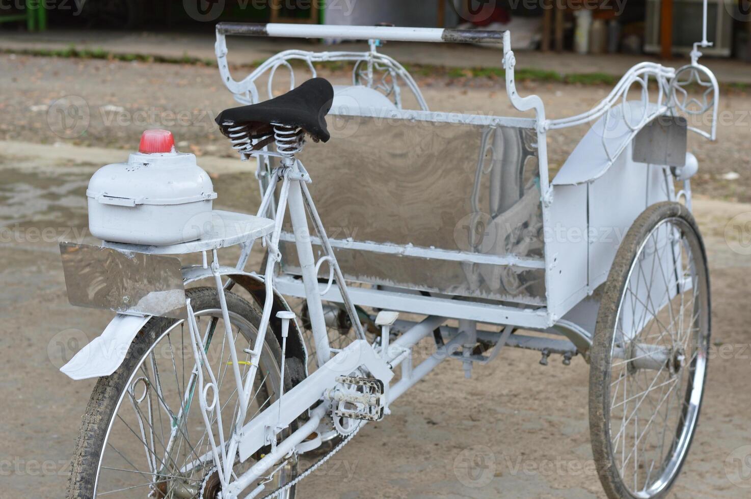 Classic white tricycle taxi with black saddle and rear light, perfect for themes of sustainable transport or traditional travel. photo