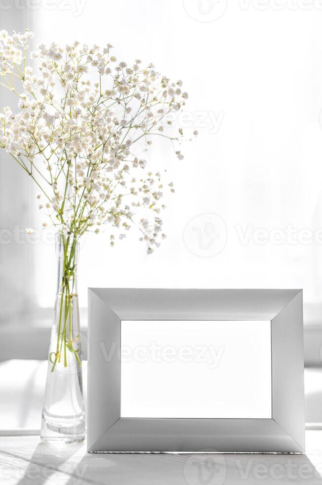White monochrome interior details Soft natural light White frame mock up Baby's breath flowers vase photo