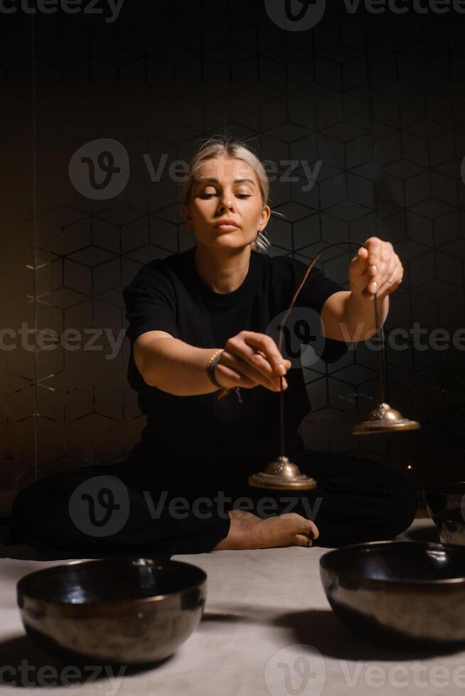 Engaging in sound healing with singing bowls in a serene indoor space, enhancing mindfulness and relaxation experience through rhythmic vibrations photo