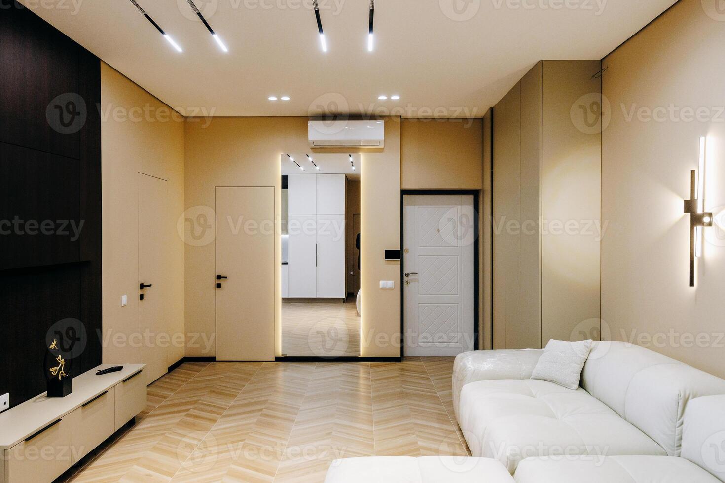 A spacious living room featuring a white couch and a large mirror on the wall photo