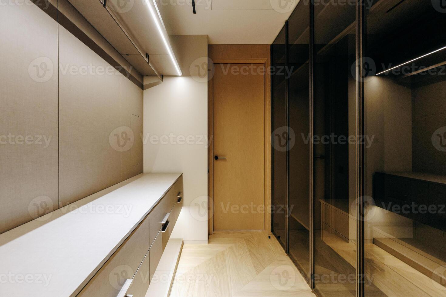 A spacious walkin closet that features numerous shelves, drawers, and a door photo