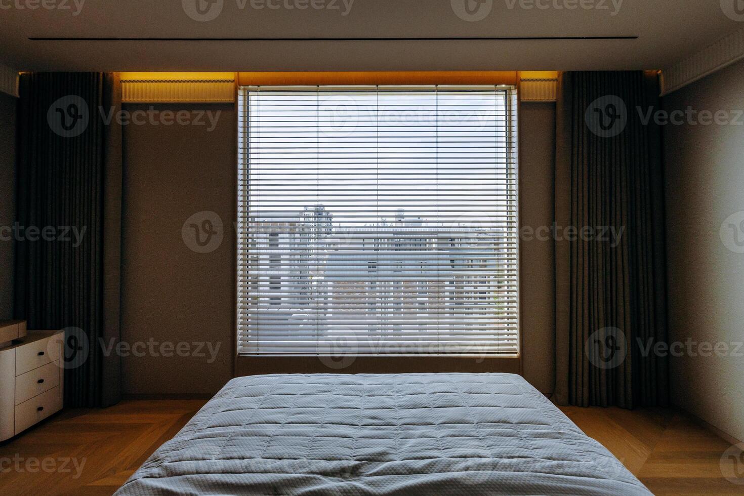 Cozy bedroom with a bed and a window featuring decorative blinds photo