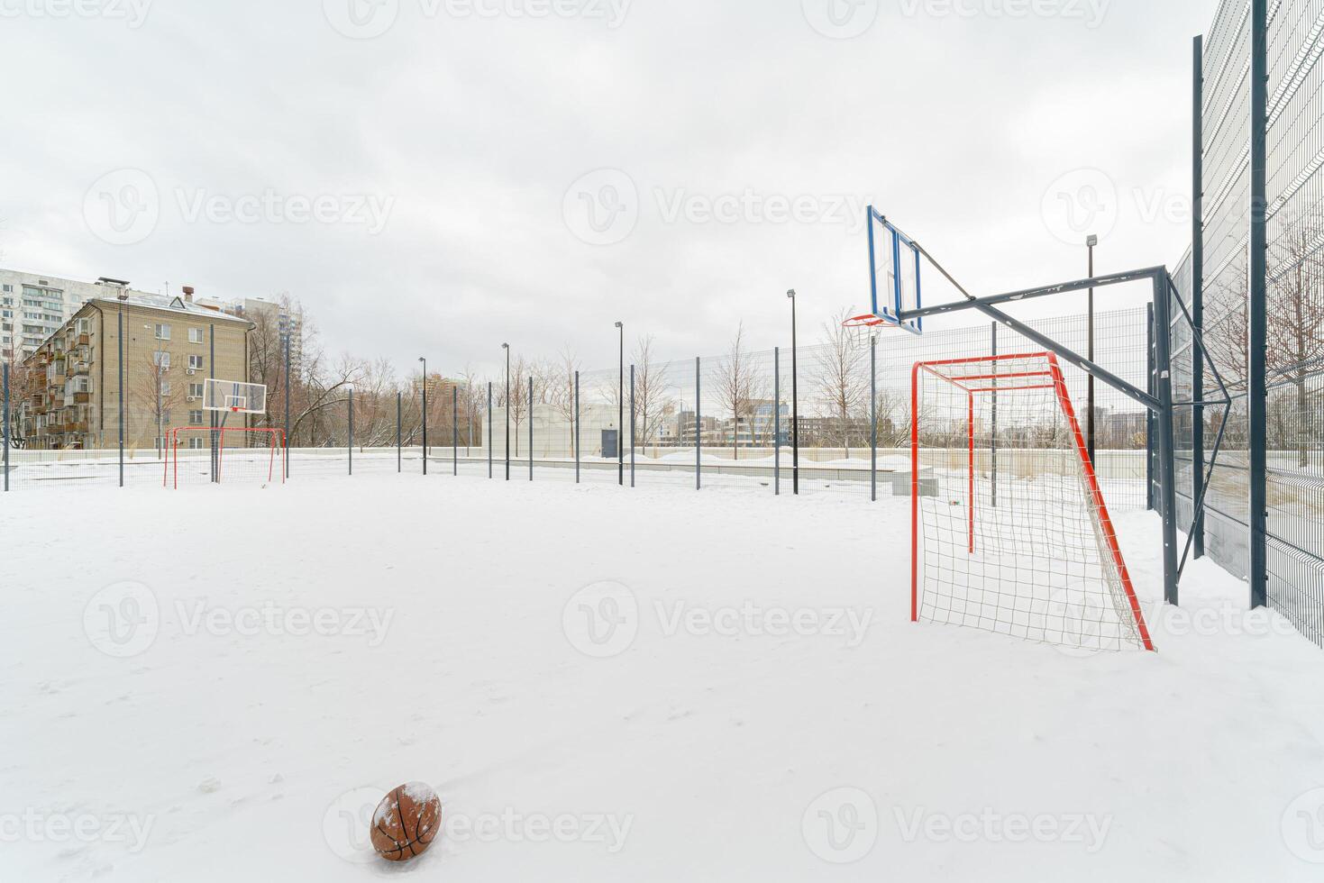 Basketball court with net and goals. The court is covered with snow. photo
