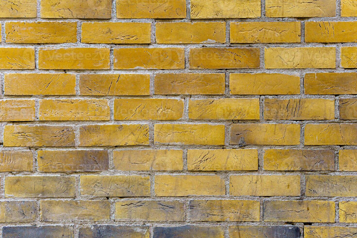 A brick wall with a yellow color. The bricks are arranged in a pattern. photo
