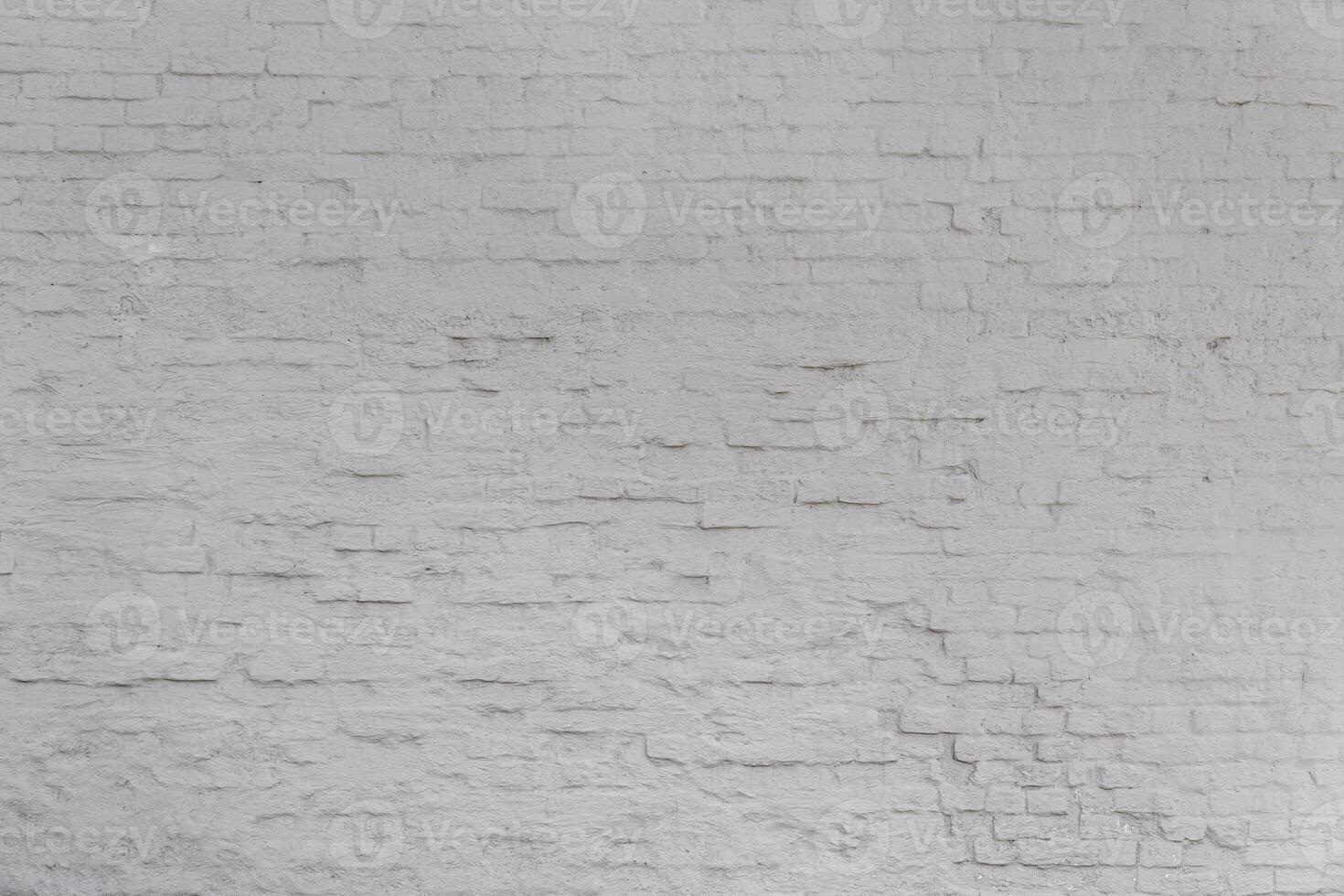 A wall made of white brick. The wall is very old and has many uneven surfaces. photo