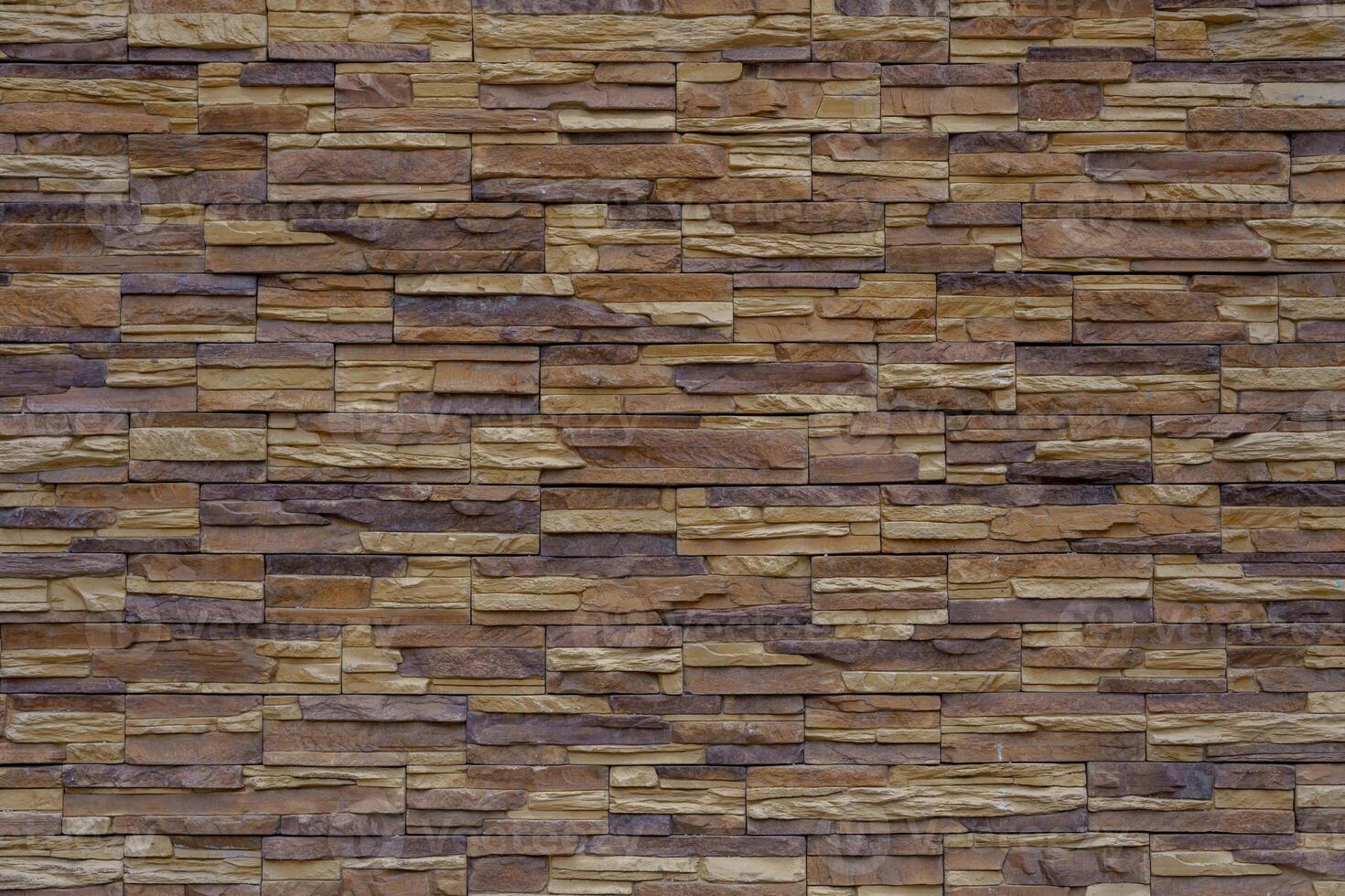 Wall made of brown and beige vintage bricks. The bricks are laid in a pattern. photo