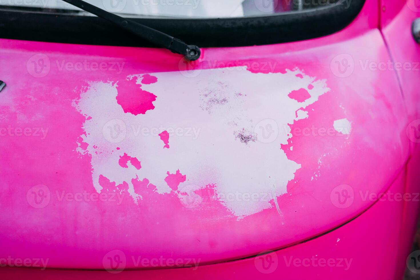 Distinctive pink vehicle with faded paint showcasing wear in urban setting during daylight hours photo