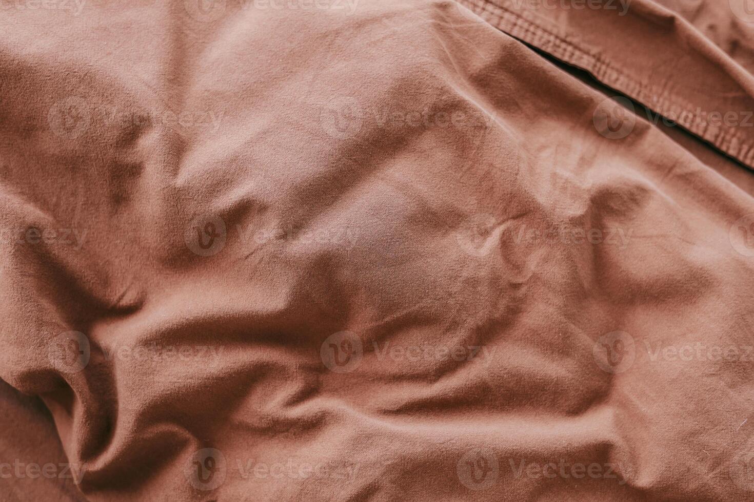 Textured brown fabric showcasing natural folds and creases in a warm inviting atmosphere photo