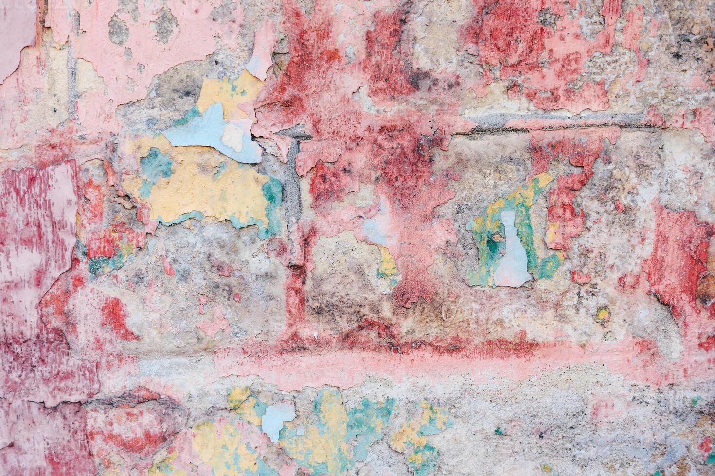 Textured wall revealing layers of history with vibrant peeling paint and colors in urban setting photo
