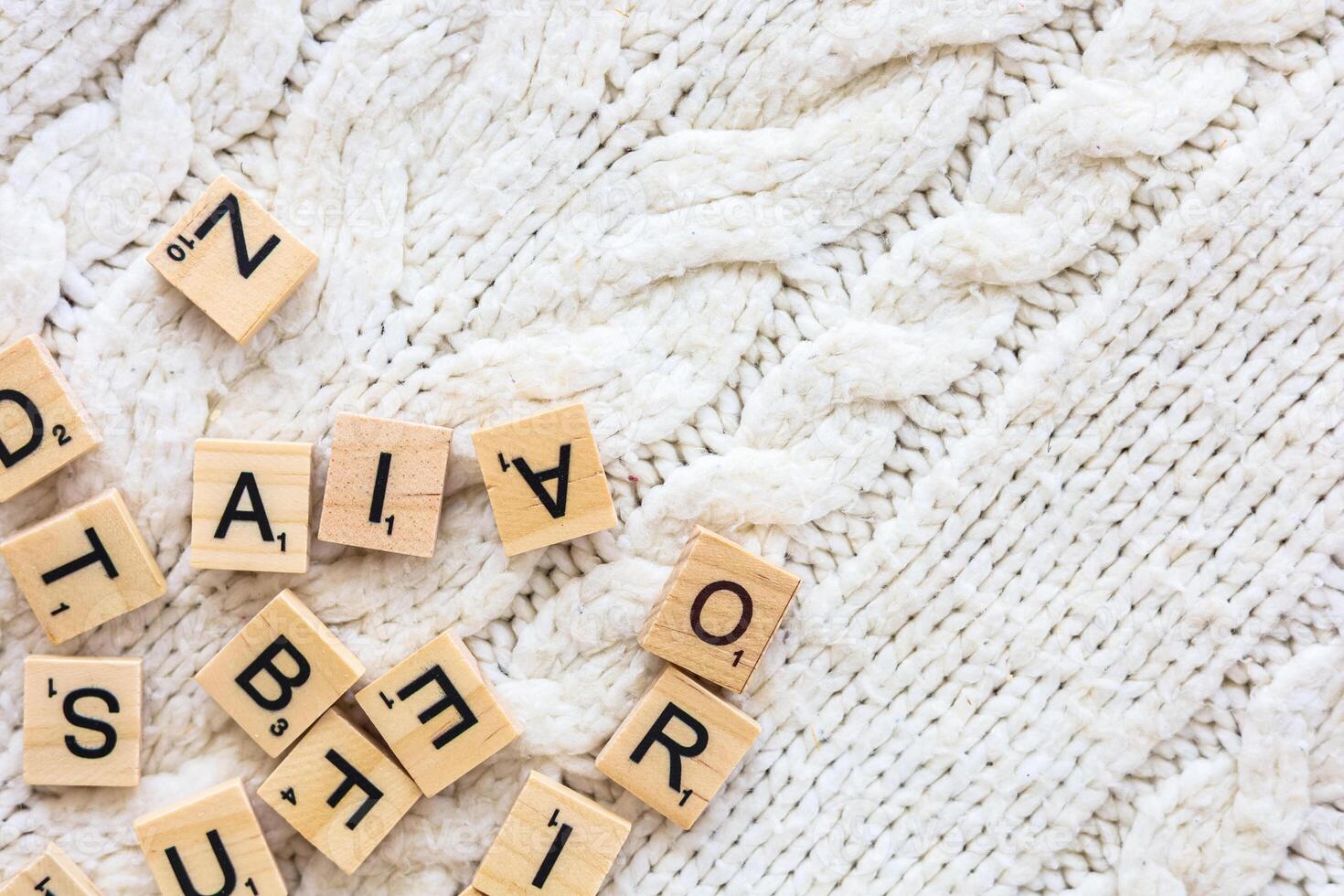 Scrabble tiles scattered on a cozy knit sweater during a relaxed indoor afternoon activity photo