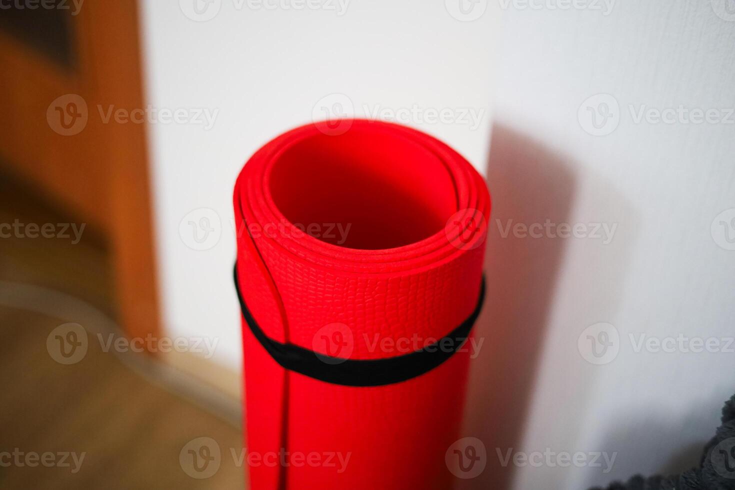Bright red yoga mat ready for relaxation and mindfulness practice in a cozy indoor space photo