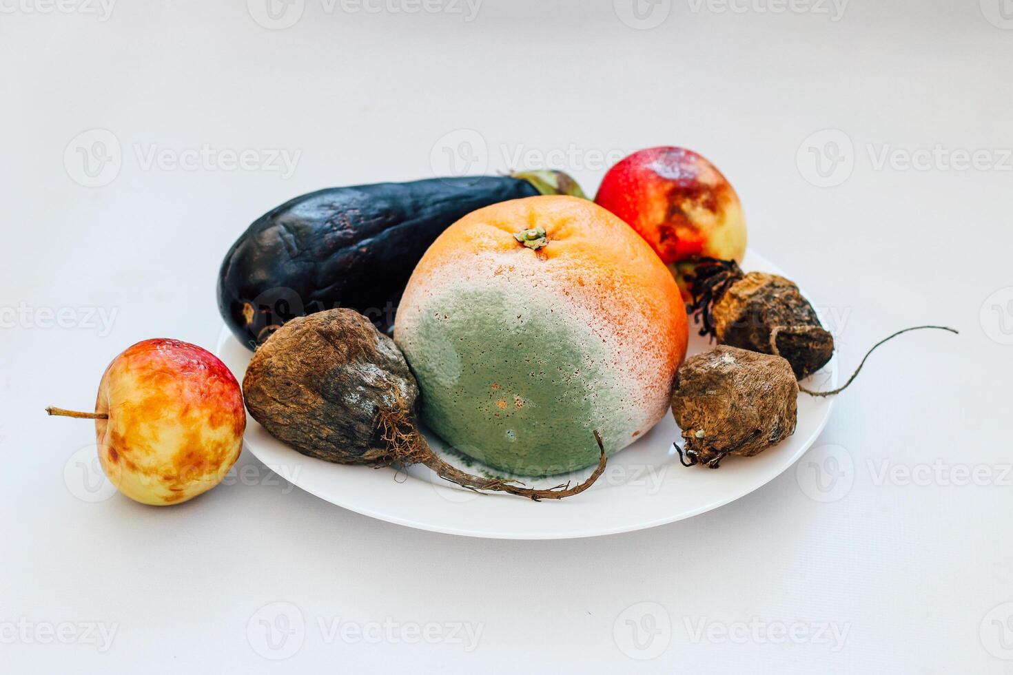 Colorful arrangement of fruits and vegetables on a white plate in a kitchen setting photo