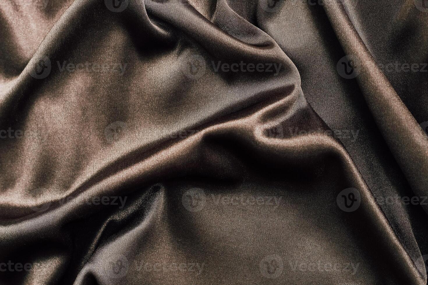 Luxurious dark fabric with elegant drapes and soft texture in natural light photo