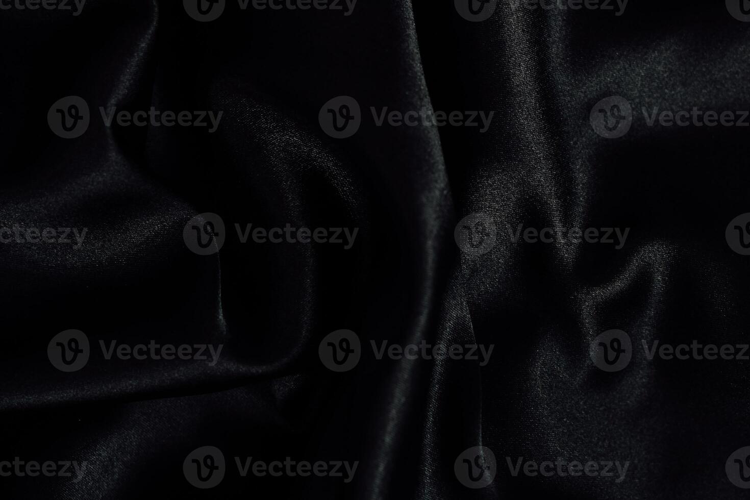 Elegant black fabric drapery showcases texture and sheen in a soft light setting photo