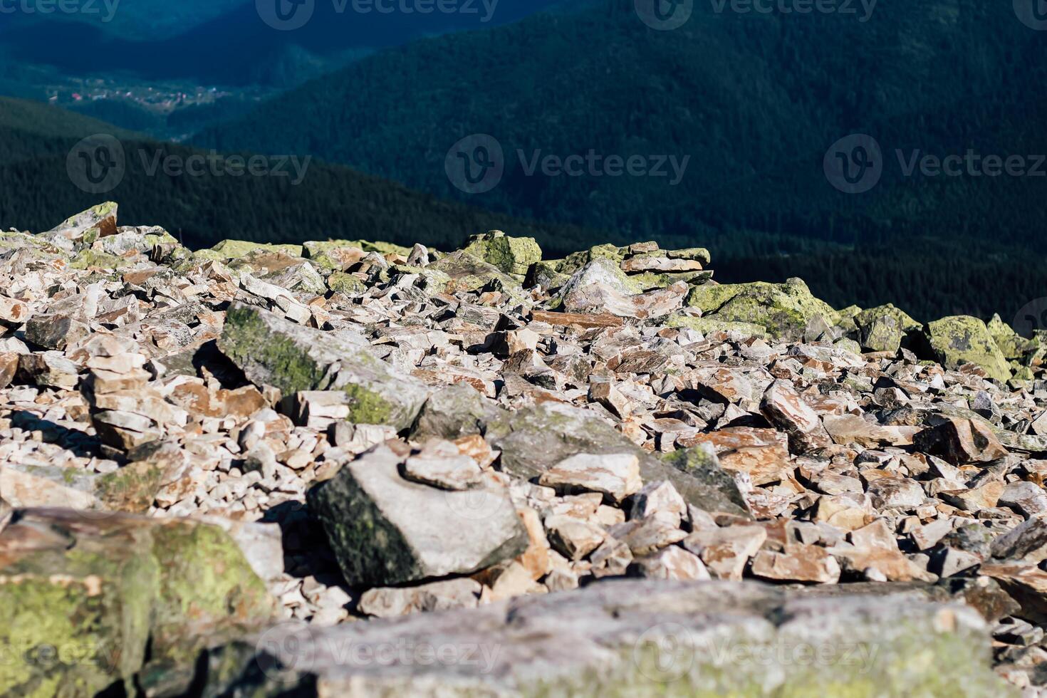 Boulders and rocky terrain under a clear blue sky in a mountain landscape photo
