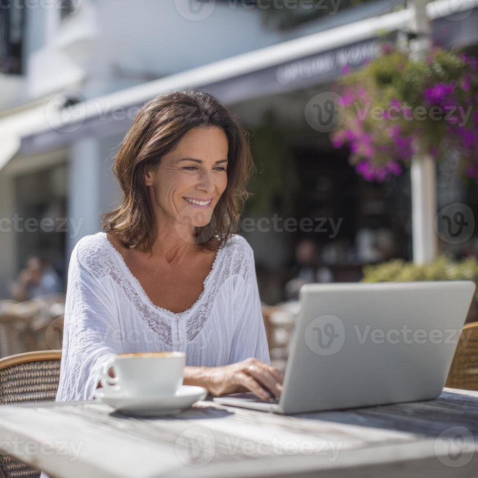 Woman Working on Laptop at a Sunny Cafe photo