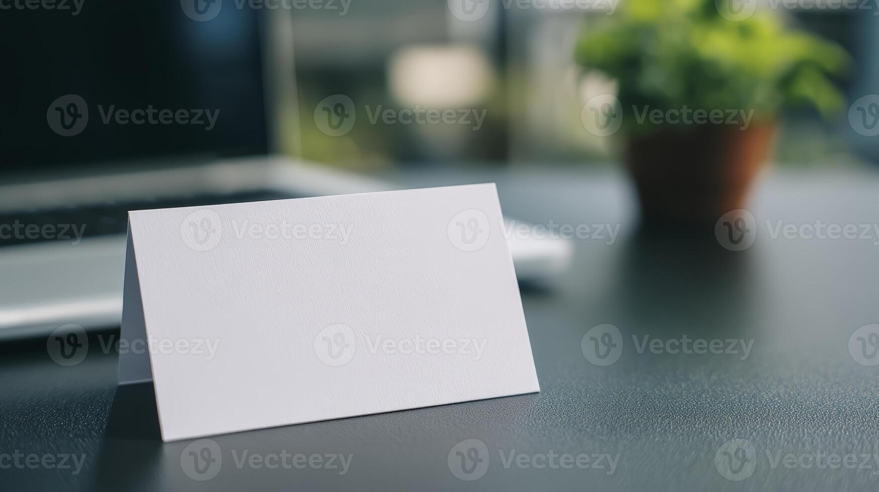 Blank White Card Mockup On Dark Desk With Laptop And Plant photo