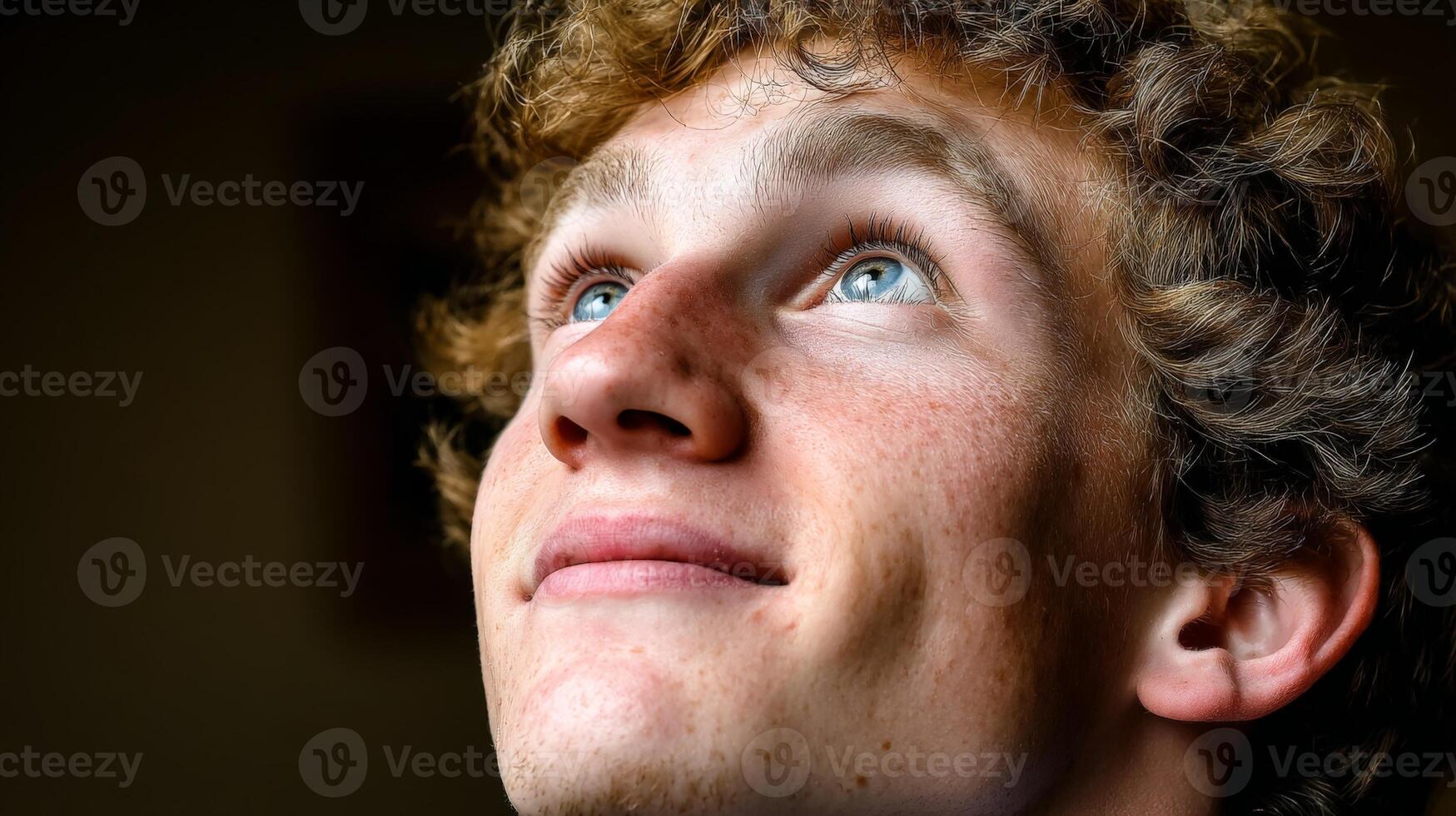 Dramatic Low Key Portrait of Young Man with Red Hair and Blue Eyes photo