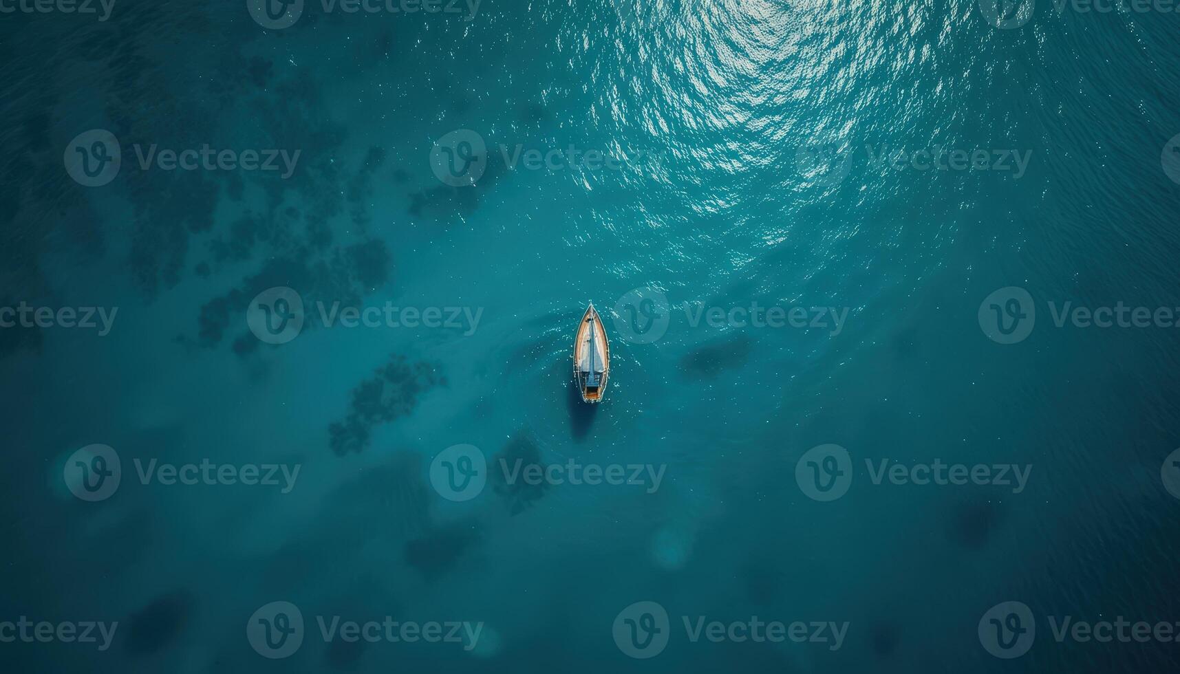 Aerial View Of Sailboat On Teal Ocean With Glistening Sunlight photo