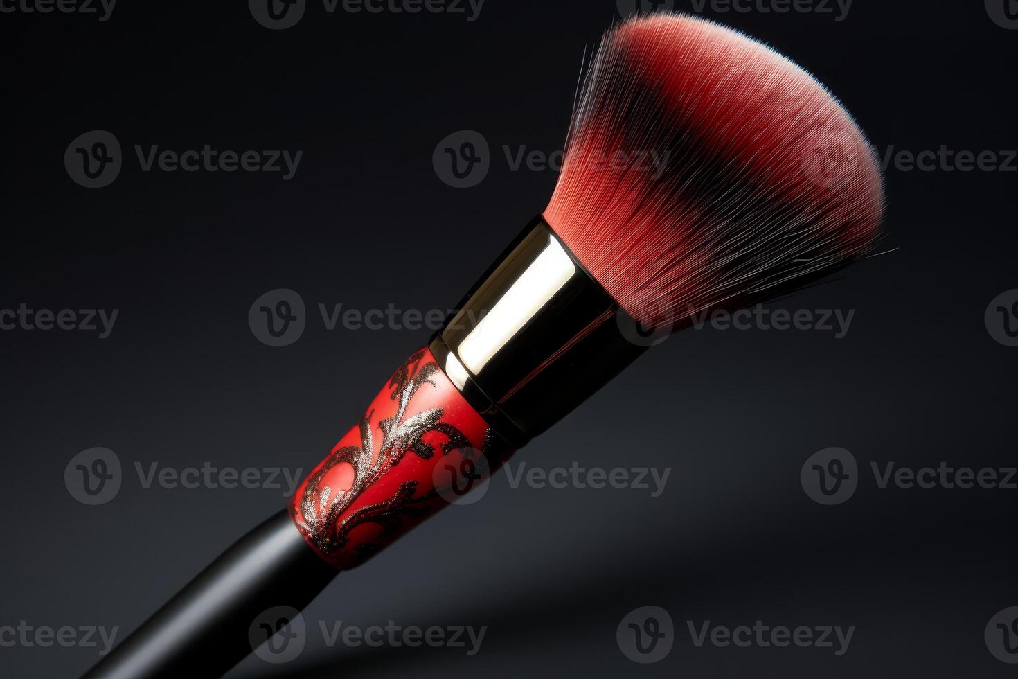 Professional makeup brush with red bristles and ornate handle on dark background photo