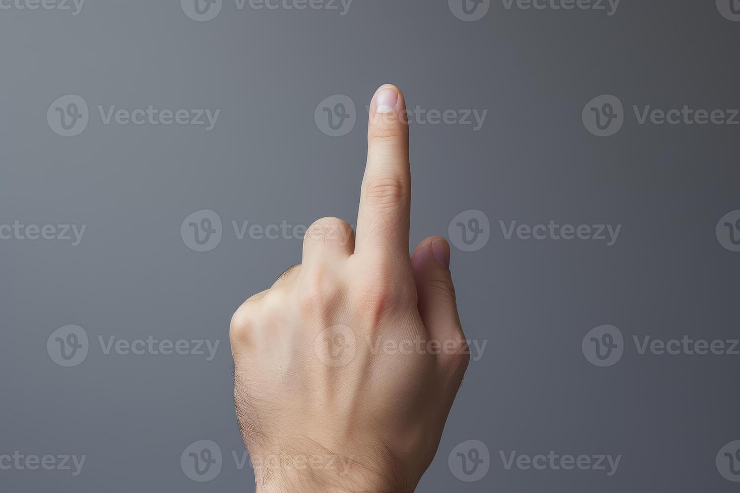 Male hand pointing up with index finger on gray background photo