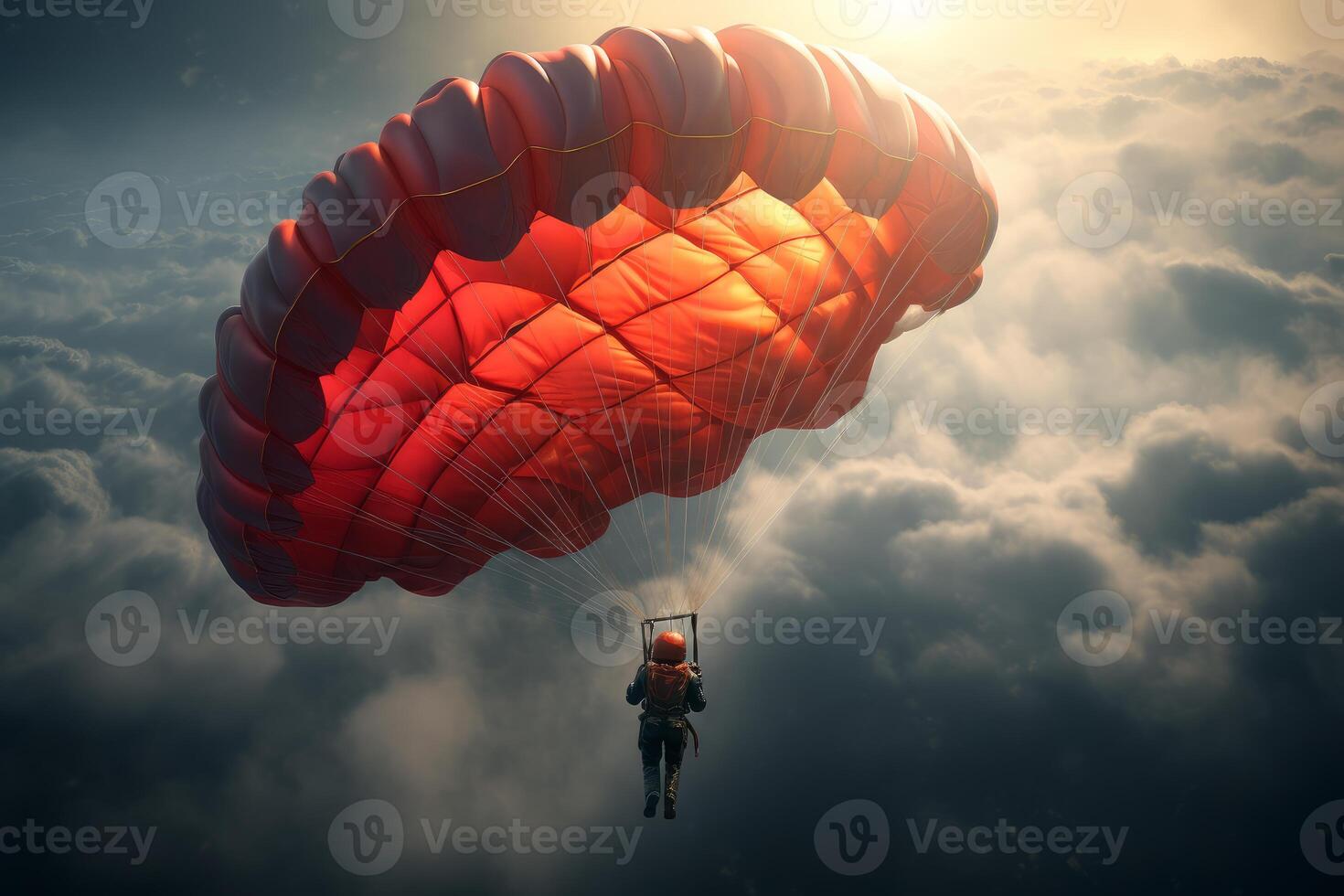 Skydiver gliding with red parachute over dramatic cloudscape at sunset photo
