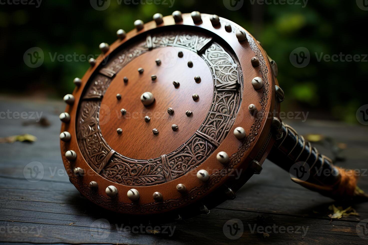 Round wooden shield with metal studs and carvings resting on table photo