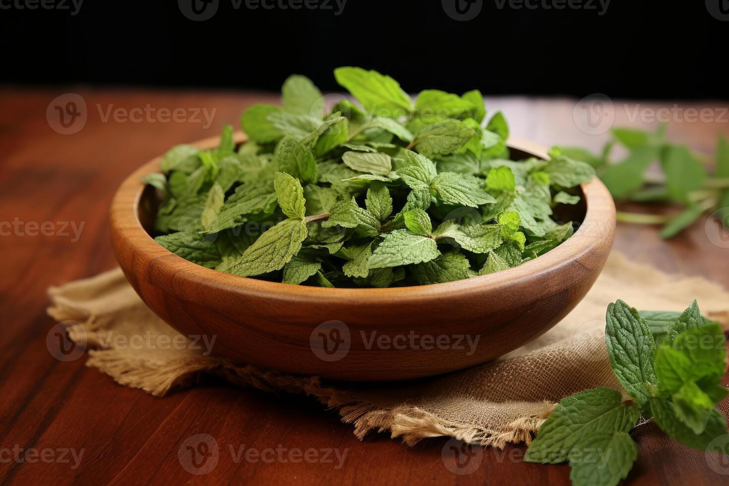 Fresh mint leaves resting in wooden bowl on rustic table photo