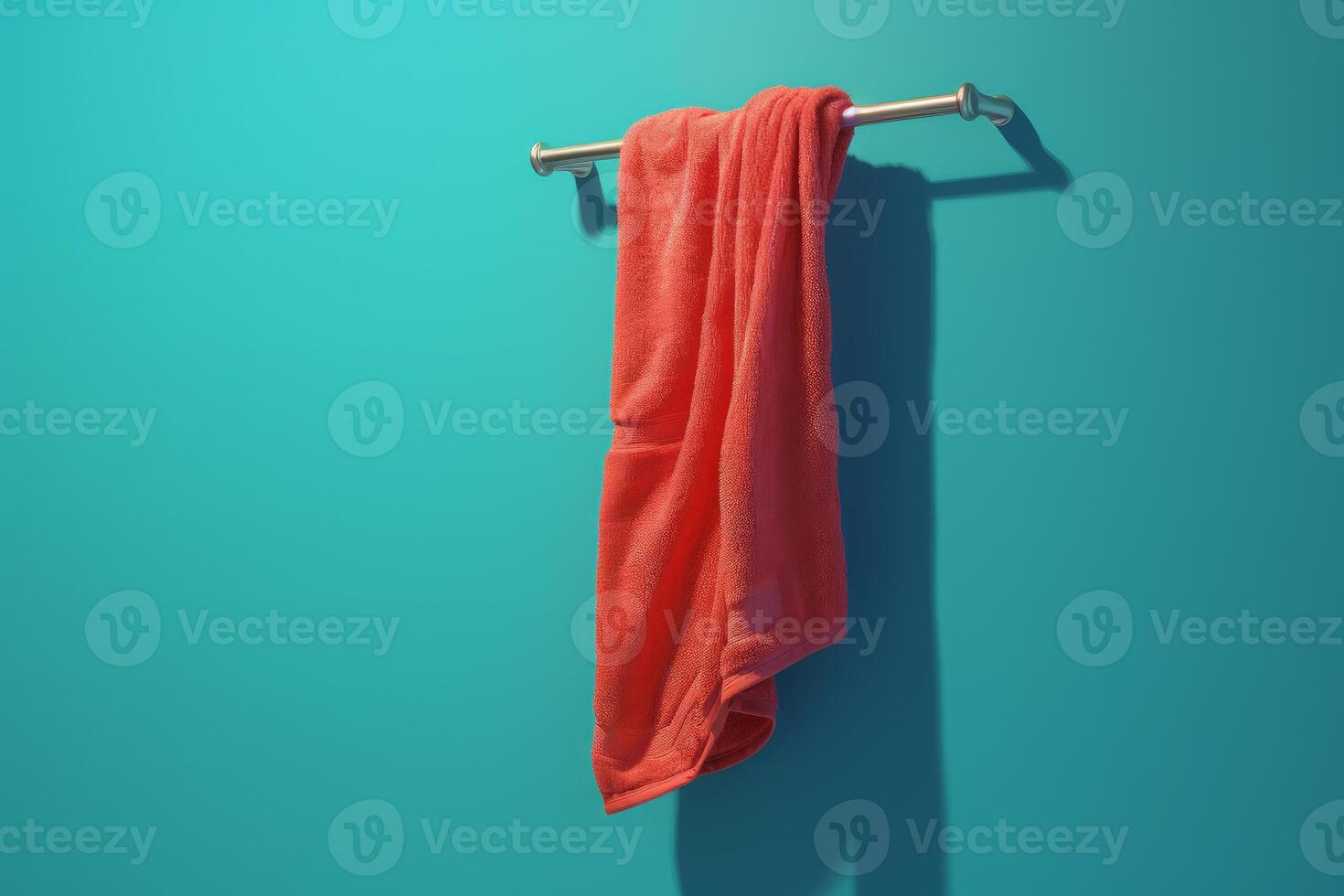 Clean red towel hanging on a towel rail against turquoise wall photo